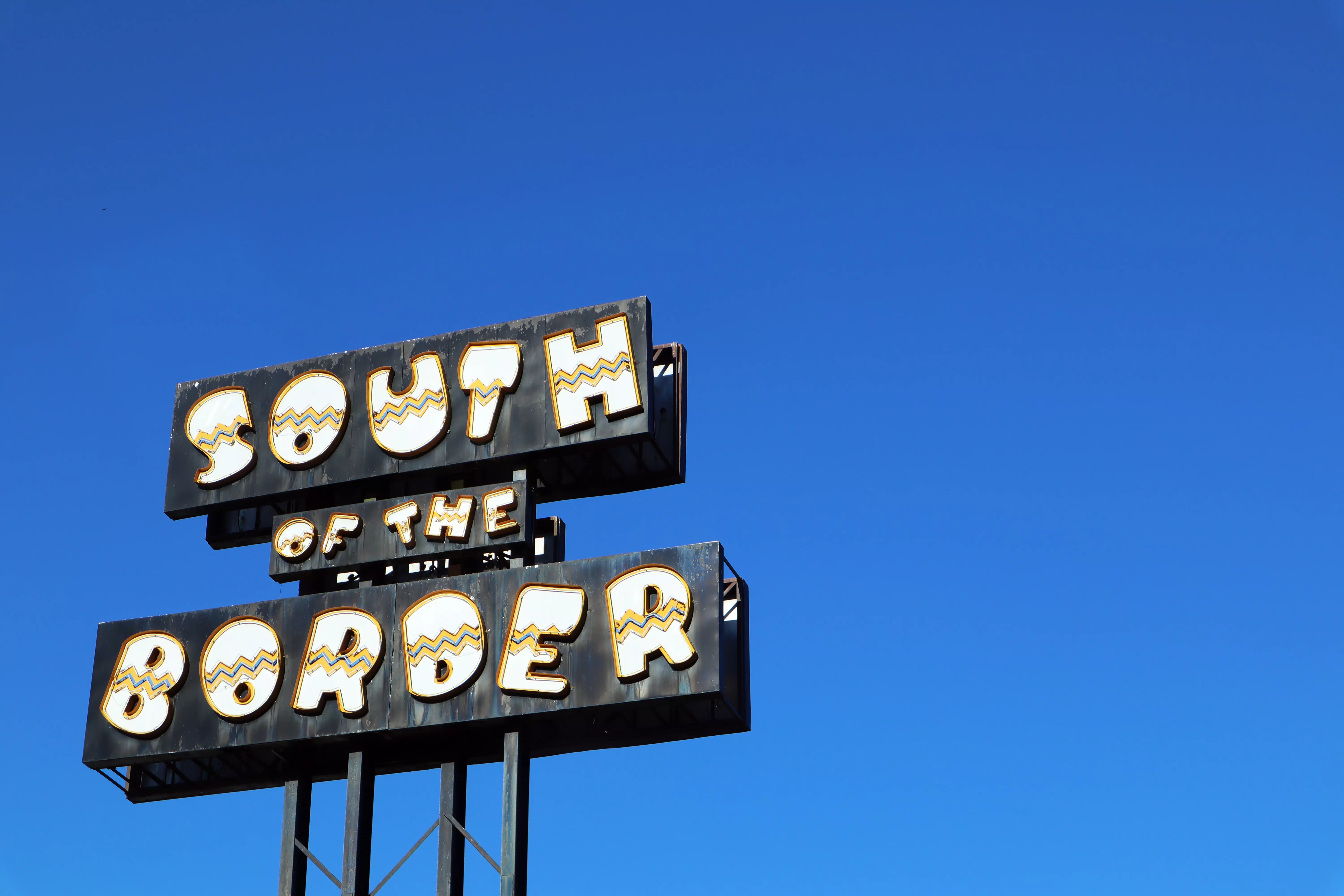 The primary South of the Border Sign against a bright blue sky